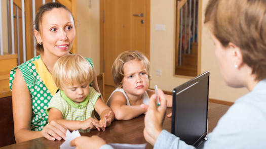 Social worker talking to a family (credit: JackF / Adobe Stock)