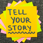 Pile of post-it notes with the top one reading 'tell your story'