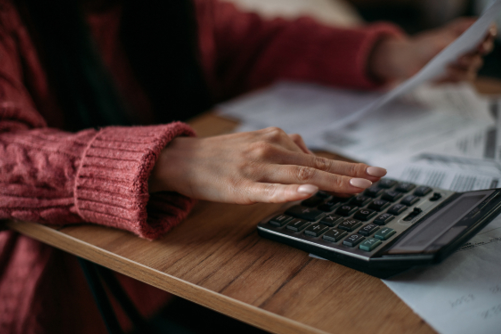 A woman using a calculator to calculate her pay